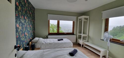 ein Krankenhauszimmer mit 2 Betten und einem Fenster in der Unterkunft D'Hestia - Gîte avec vue imprenable sur Huy in Huy