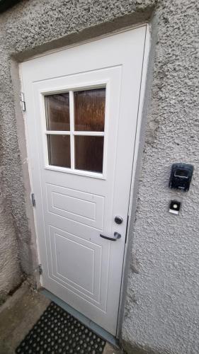 a white garage door with a window on a building at Lofoten Overnatting - Ballstad in Ballstad