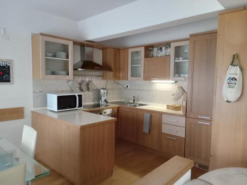 a kitchen with wooden cabinets and a microwave at La Casa Shabby in Marilleva