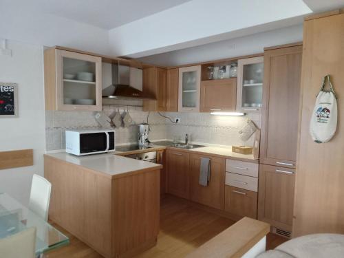 kuchnia z drewnianymi szafkami i mikrofalówką w obiekcie La Casa Shabby w mieście Marilleva