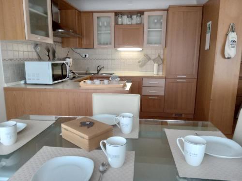 kuchnia ze stołem z kubkami i kuchenką mikrofalową w obiekcie La Casa Shabby w mieście Marilleva