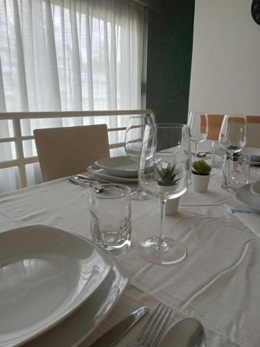 a table with white plates and glasses on it at La Casa Shabby in Marilleva