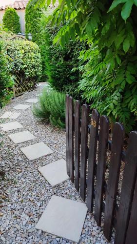 une clôture en bois en face d'un jardin dans l'établissement Maison de vacances en Vaison Ventoux, à Vaison-la-Romaine