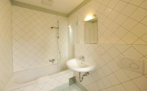 a white bathroom with a sink and a shower at Zum goldenen Engel - Fam. Ehrenreich in Krems an der Donau