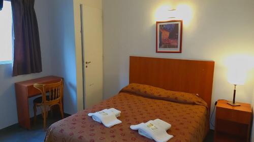 a bedroom with a bed with two towels on it at Hotel Caribe in Mar del Plata