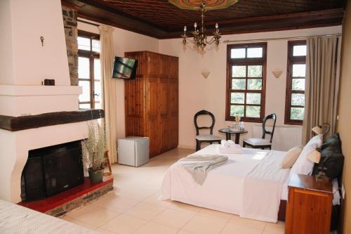 a bedroom with a bed and a fireplace at Pliades Traditional Guesthouse in Palaios Panteleimon