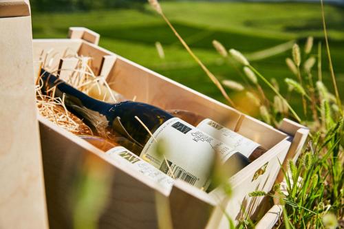 a box with a bottle of wine in the grass at Barta Pince Vendégház Mád in Mád