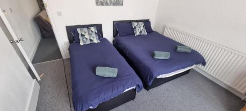 2 Betten in einem Zimmer mit lila Bettwäsche und Kissen in der Unterkunft Sheffield City Suites in Manor