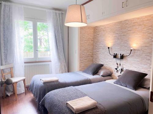 a bedroom with two beds and a brick wall at Casa Andorrana - ¡A Pie de todo! in Encamp