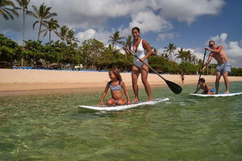 a couple of people on surfboards in the water at The Westin Resort Nusa Dua, Bali in Nusa Dua
