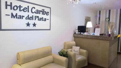 a waiting room with a couch and a hotel carribean manld plate sign at Hotel Caribe in Mar del Plata