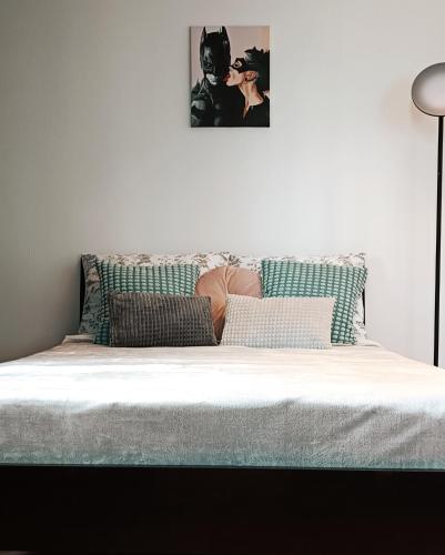 1 cama con sábanas blancas y una foto en la pared en Duży prywatny pokój blisko Starego Miasta. Pokój 7 en Varsovia