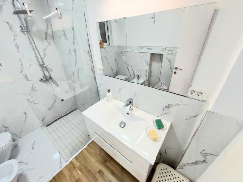 a white bathroom with a sink and a shower at Apartment Sea & Mountain in Bar