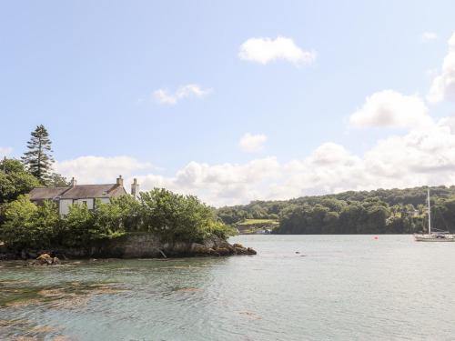 a house on an island in a body of water at Ynys Faelog Cottage in Menai Bridge