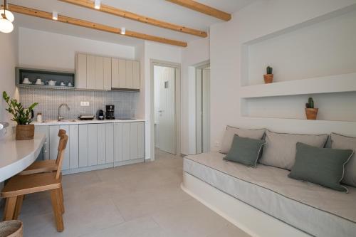 a living room with a couch and a kitchen at Castello Amorgos Suites in Katapola
