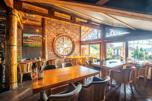 a restaurant with tables and chairs and a brick wall at Vlasinsko jezero VILA BEST in Surdulica