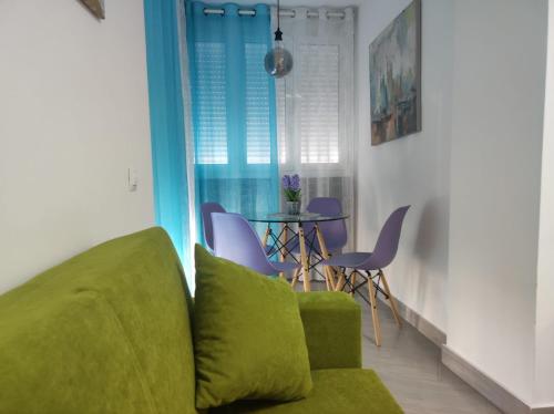 トロクス・コスタにあるEstudio El Faro IIのリビングルーム(緑のソファ、テーブル付)