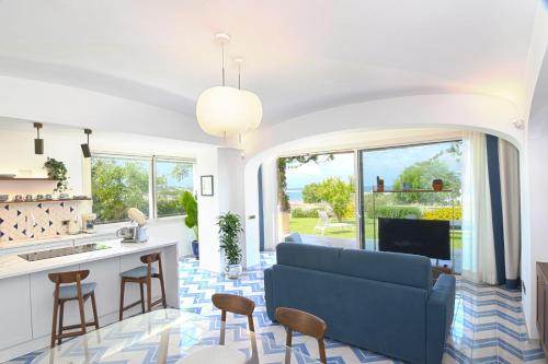 a living room with a blue couch and a kitchen at OraBlu Exclusive Villas in Ischia