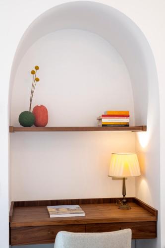 a room with a desk with a lamp and books at OraBlu Exclusive Villas in Ischia