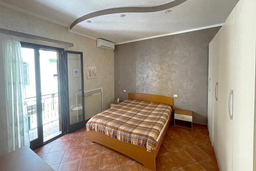 a bedroom with a bed and a large window at Luxury Apartments Campofelice in Campofelice di Roccella