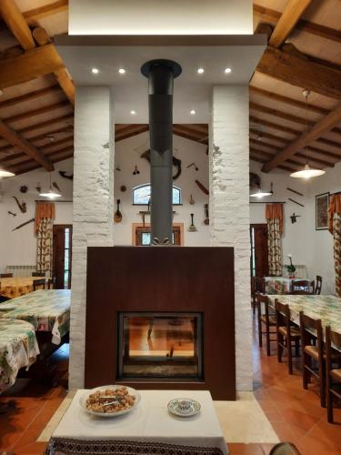 a fireplace in a dining room with tables and chairs at Il Canto del Sole in Monteroni dʼArbia