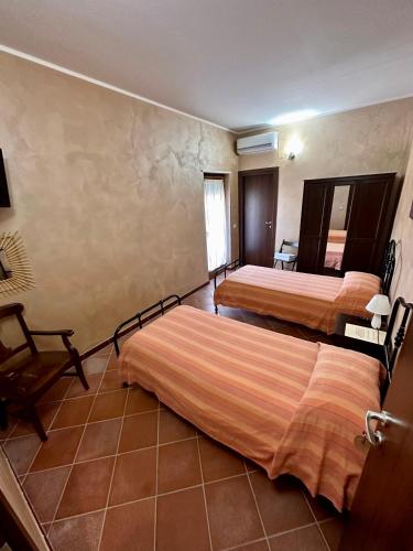 a hotel room with two beds and a chair at Agriturismo Il Pozzo in Polla