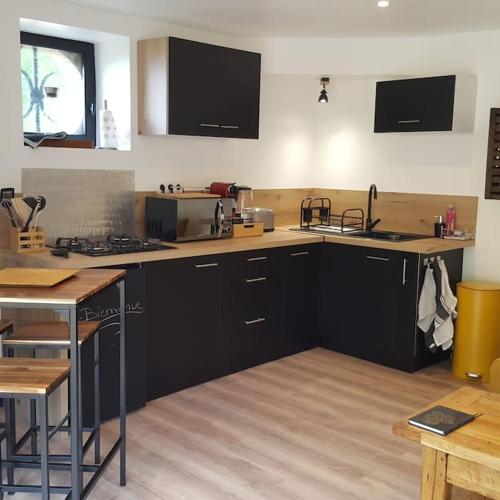 une cuisine avec des armoires noires et un comptoir dans l'établissement Appartement 2 pieces, à Gravières