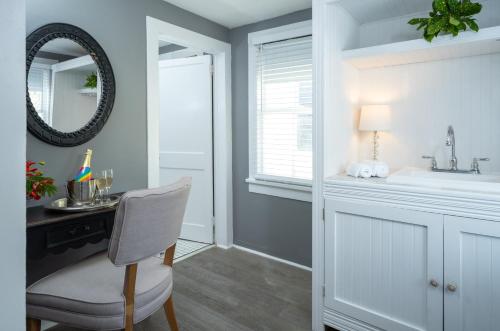 a bathroom with a sink and a desk and a mirror at Alexander's Guesthouse-Adult Exclusive, LGBTQ Friendly in Key West