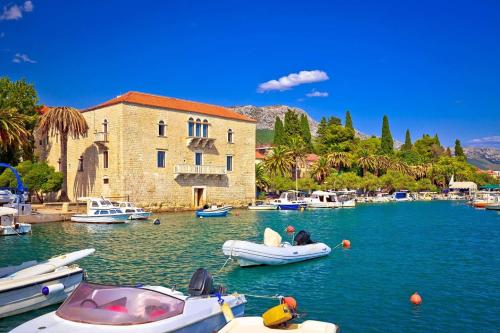 a group of boats in the water next to a building at Apartman LIBRA in Kaštela