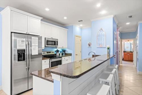 a kitchen with white appliances and blue walls at Seas The Dream at The Villages of Crystal Beach in Destin