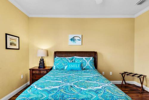 a bedroom with a bed with a blue comforter at Seas The Dream at The Villages of Crystal Beach in Destin