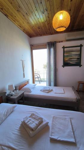 a bedroom with two beds and a large window at Ntaskas apartments in Poulithra