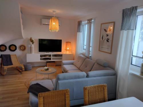 a living room with a couch and a tv at Mormin in Dobrojewo