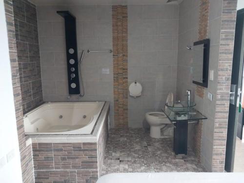 a bathroom with a bath tub and a toilet at HOTEL DULCES SUEÑOS in Buenaventura