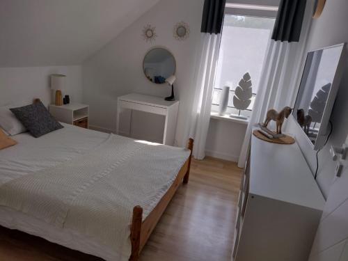 a bedroom with a bed and a mirror and a window at Mormin in Dobrojewo
