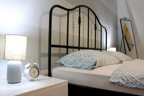 ein Schlafzimmer mit einem Bett und einer Uhr auf einem Nachttisch in der Unterkunft FJAKA - Kuća za odmor - NP Krka in Drniš