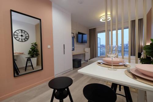 a living room with a table and chairs and a mirror at Apartamenty Centrum in Białystok