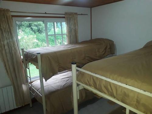 two bunk beds in a room with a window at Finca Lo de Guarin in Vaqueros