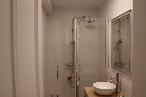 uma casa de banho com uma cabina de duche em vidro e um lavatório. em Apartamento La Verita Santiago em Santiago de Compostela