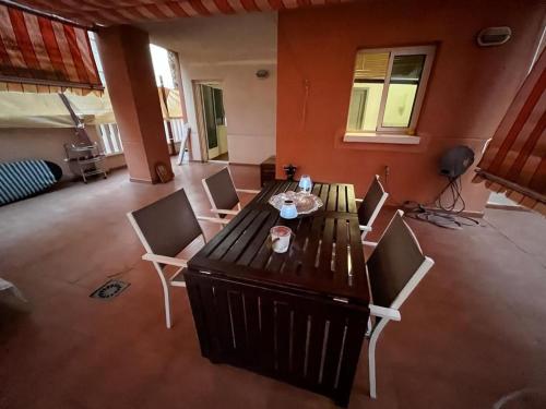 sala de estar con mesa de madera y sillas en Apartamento La Manga Del Mar Menor, en La Manga del Mar Menor