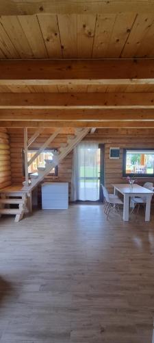 Großes Zimmer mit einem Tisch und einer Treppe in der Unterkunft Park Resort Trzęsacz in Trzęsacz