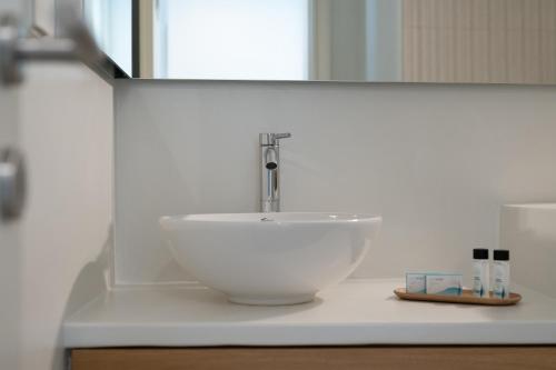 a white bowl sink on a counter in a bathroom at Castello Amorgos Suites in Katapola