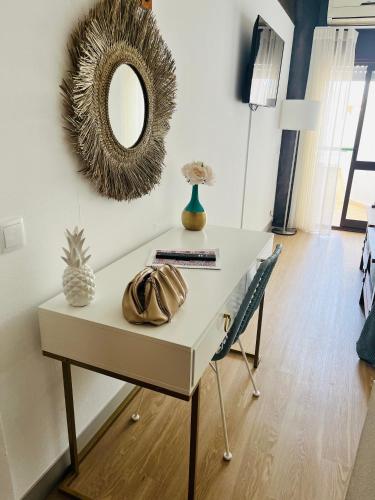 a table with a mirror and a chair in a room at Sunset Lover Aparthotel Guadiana in Monte Gordo