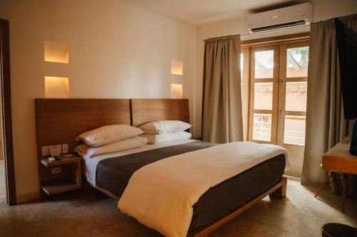 a bedroom with a large bed and a window at Billini Hotel, Historic Luxury in Santo Domingo