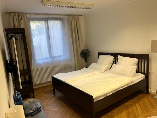 a bedroom with a bed with white sheets and a window at Wohnung im Universitätsring in Halle an der Saale