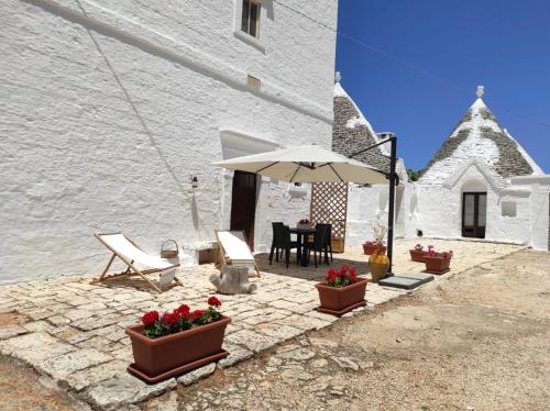 een terras met een tafel, stoelen en een parasol bij Masseria Helianthus in Ceglie Messapica