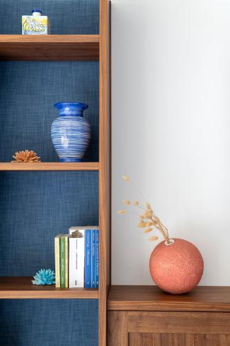 a book shelf with books and a vase on it at OraBlu Exclusive Villas in Ischia