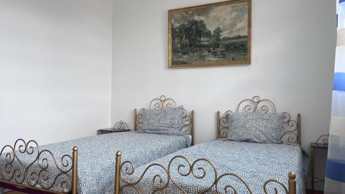 - 2 lits dans une chambre avec une photo sur le mur dans l'établissement Maison dans un endroit calme, à Saint-Leu-la-Forêt