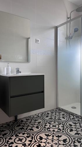une salle de bain avec un lavabo et une douche dans l'établissement Maison dans un endroit calme, à Saint-Leu-la-Forêt