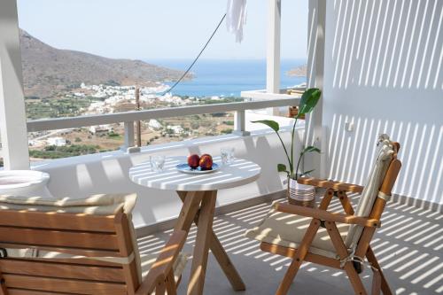 a table and chairs on a balcony with a view of the ocean at Castello Amorgos Suites in Katapola